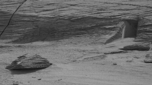 美国宇航局（NASA）送上火星的好奇号（Curiosity）探测车发回的新照片上看到一个奇怪的景象：一块大石头的下面开了一个长方形的口，看起来就像一个人造的门。